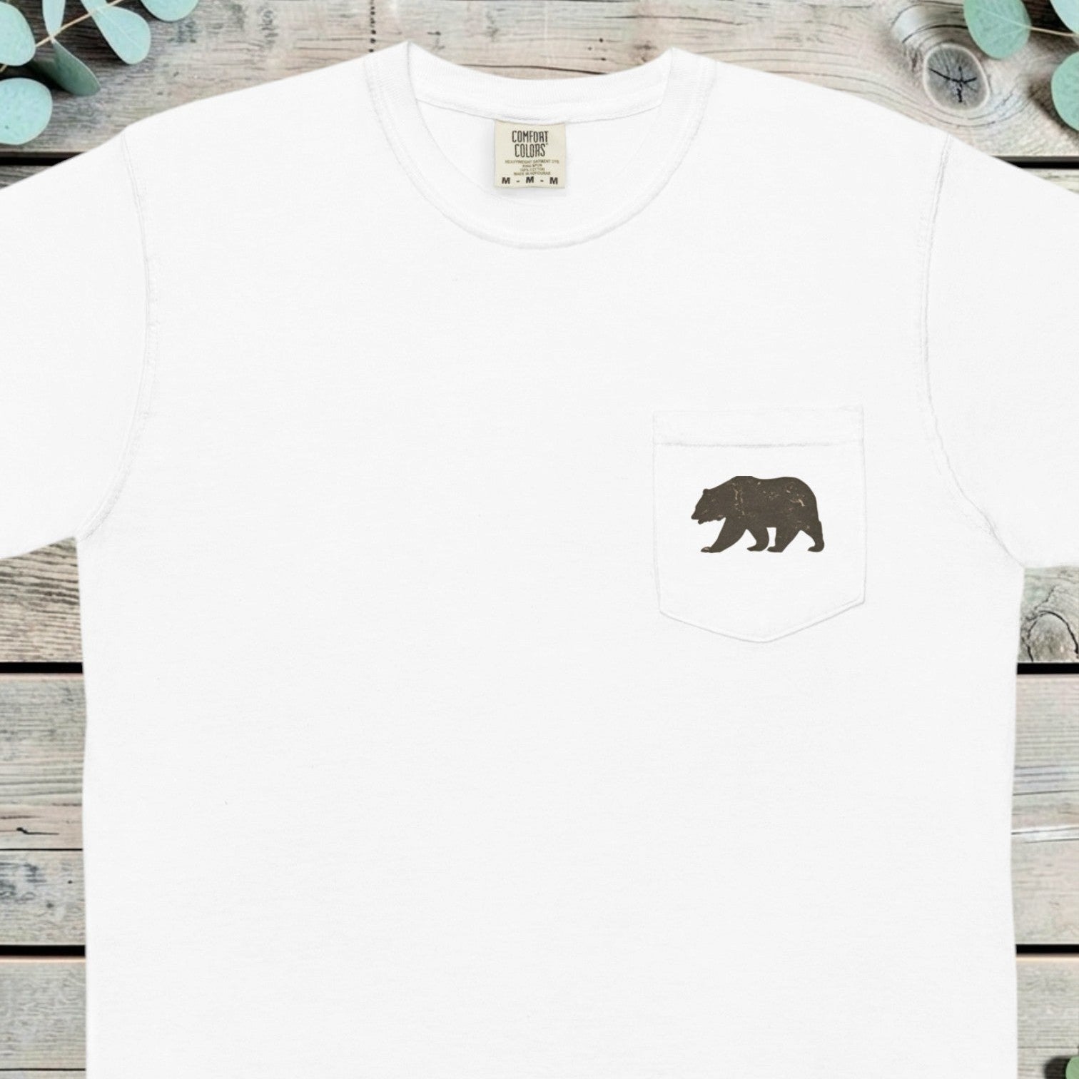 Small grizzly bear printed on the chest pocket of a t-shirt