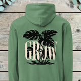 Large back print of a monstera plant silhouette behind the word GROW in serif capitals