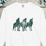 Three howling wolf silhouettes filled with a moonlit pine forest