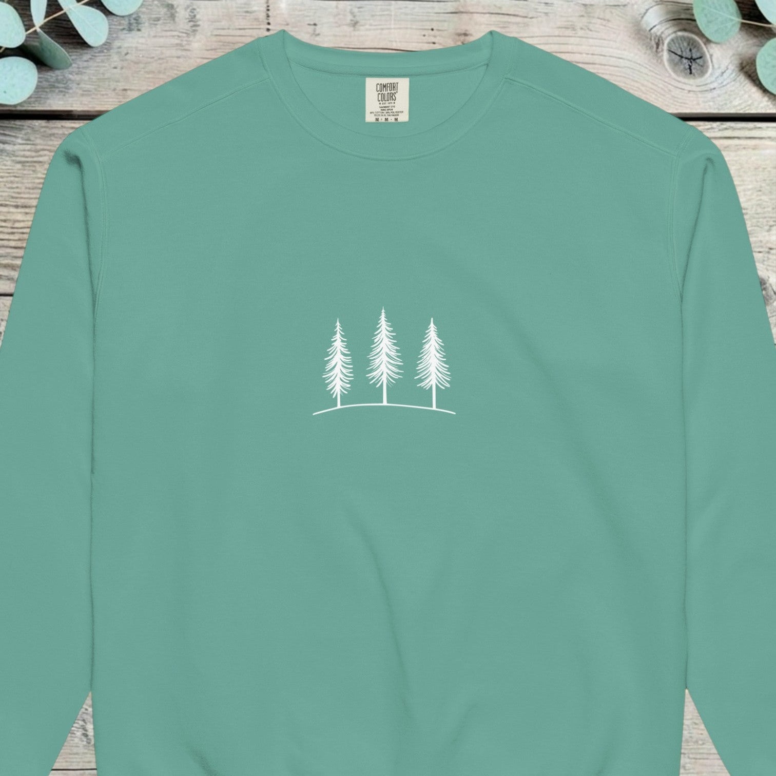 Small chest design of three simple pine trees in fine white line
