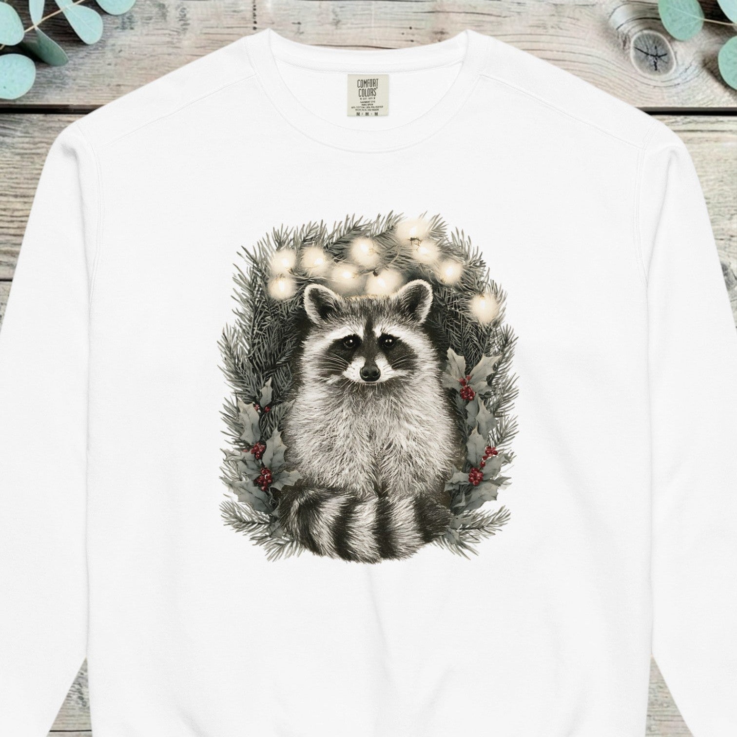 Raccoon peering out from inside a pine wreath strung with small lights