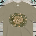 Fox curled up asleep inside a pine wreath strung with small warm lights