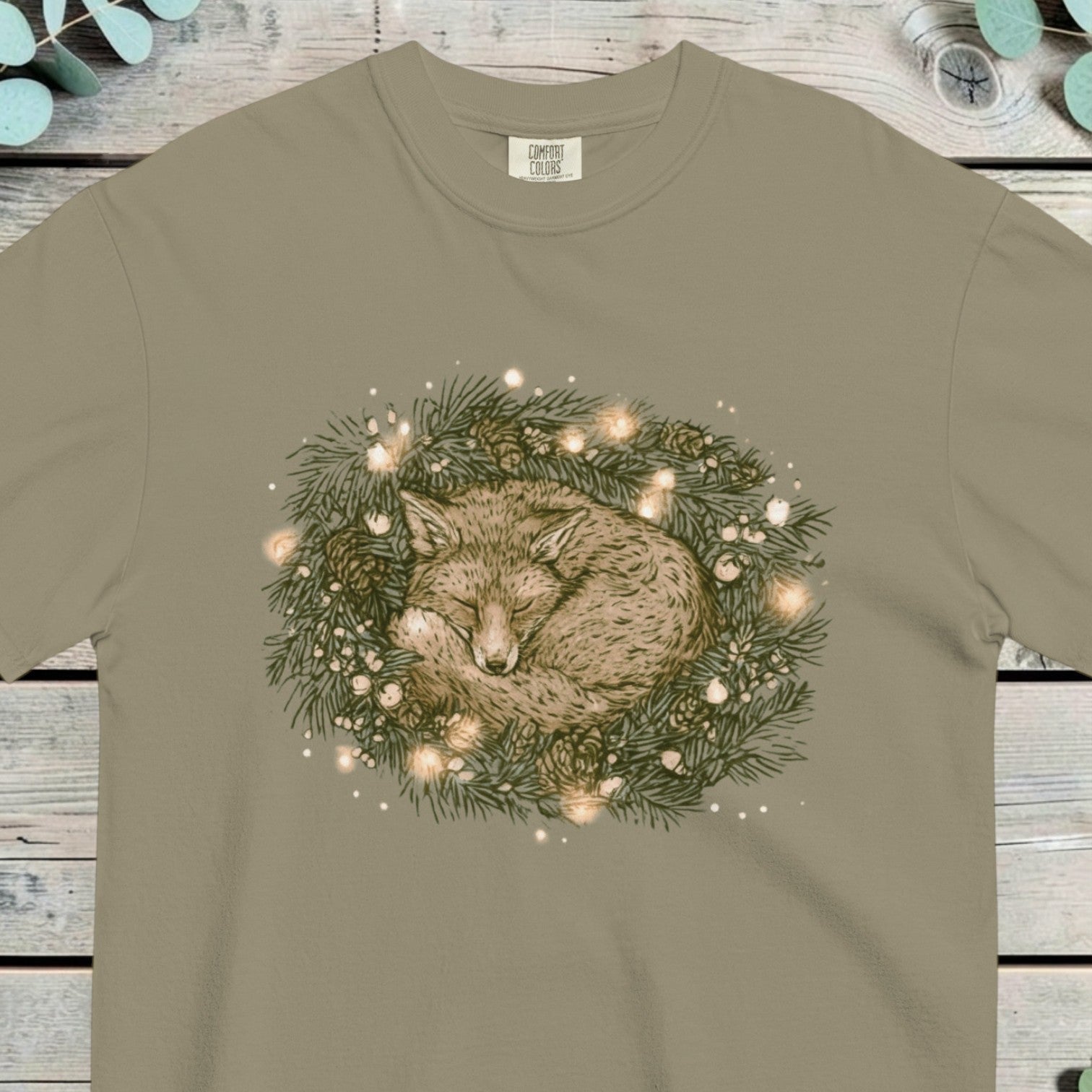 Fox curled up asleep inside a pine wreath strung with small warm lights