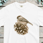 Small sparrow perched on an open pine cone, worked in soft sepia tones