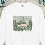 Gondola car passing above a snowy pine forest inside a soft square frame