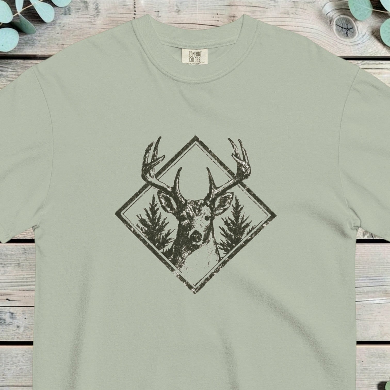 Stag head between two pine trees inside a diamond frame, antlers crossing the border