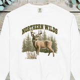 Whitetail buck standing in front of a pine forest with NORTHERN WILDS arched above