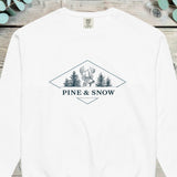 Stag head flanked by pine trees inside a diamond with PINE AND SNOW beneath it