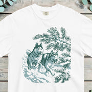 Two huskies running at full stretch through deep snow past winter pines