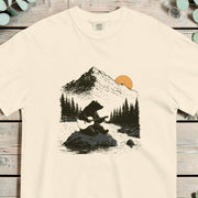 Bear sitting on a rock playing an acoustic guitar with pines and a mountain behind