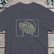 Monstera deliciosa leaf in deep green outlined in gold against a circle in a thin border