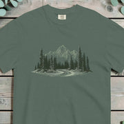 Winding two-lane road curving into dense pine forest below a rocky mountain peak