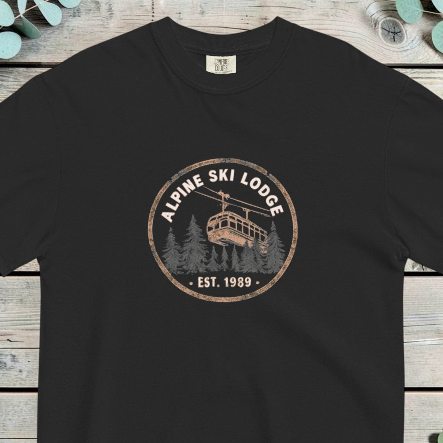 Alpine ski lodge gondola badge design on a Black garment-dyed cotton t-shirt