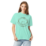 Frog in a holly wreath design on a Chalky Mint garment-dyed cotton t-shirt