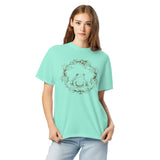 Frog in a holly wreath design on a Chalky Mint garment-dyed cotton t-shirt